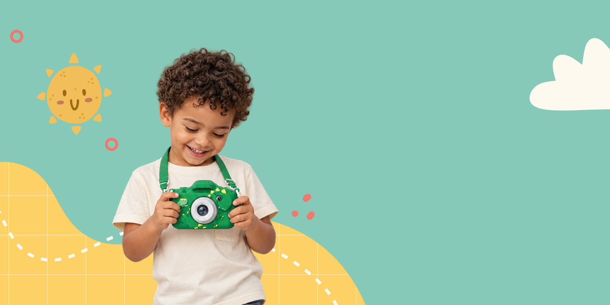 Smiling boy looking at photos on his green dinosaur Klikko kids camera